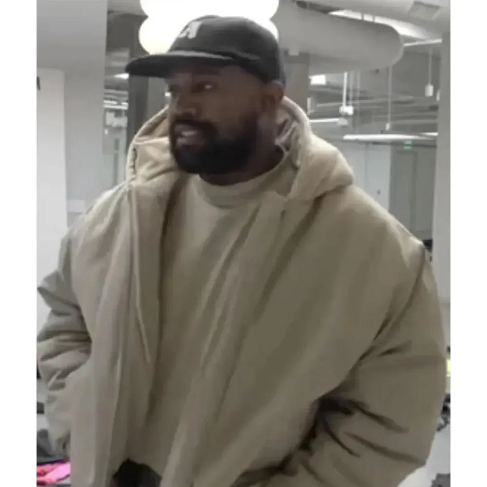 Man wearing a beige hoodie and black cap indoors